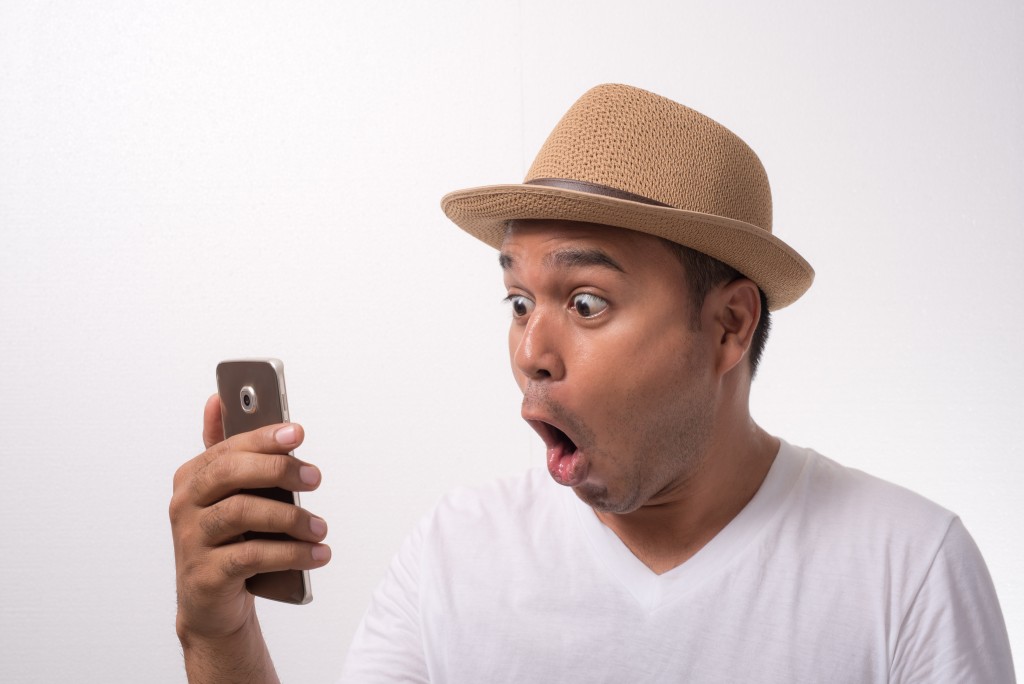 man shocked looking at his phone
