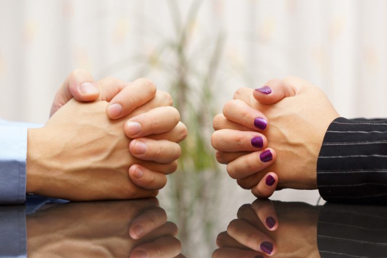 a male and female hand clasped together