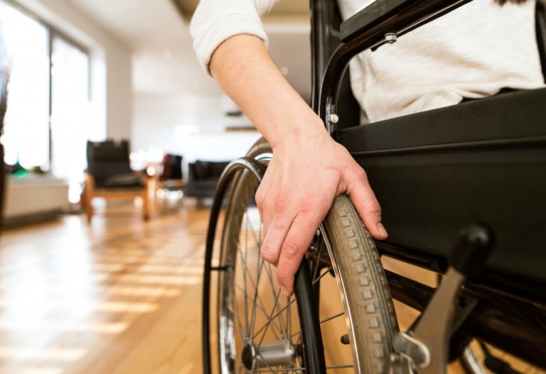 A disabled person in a wheelchair at home